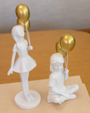 Escultura em Resina Branca Menina com balão dourado 27cm x 10cm